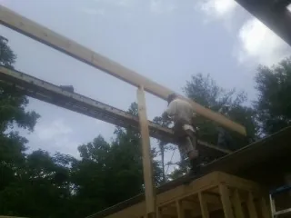 Carpenter setting a ridge beam over a new addition frame — Ice Dam Removal by Roofing Brothers in Eatontown