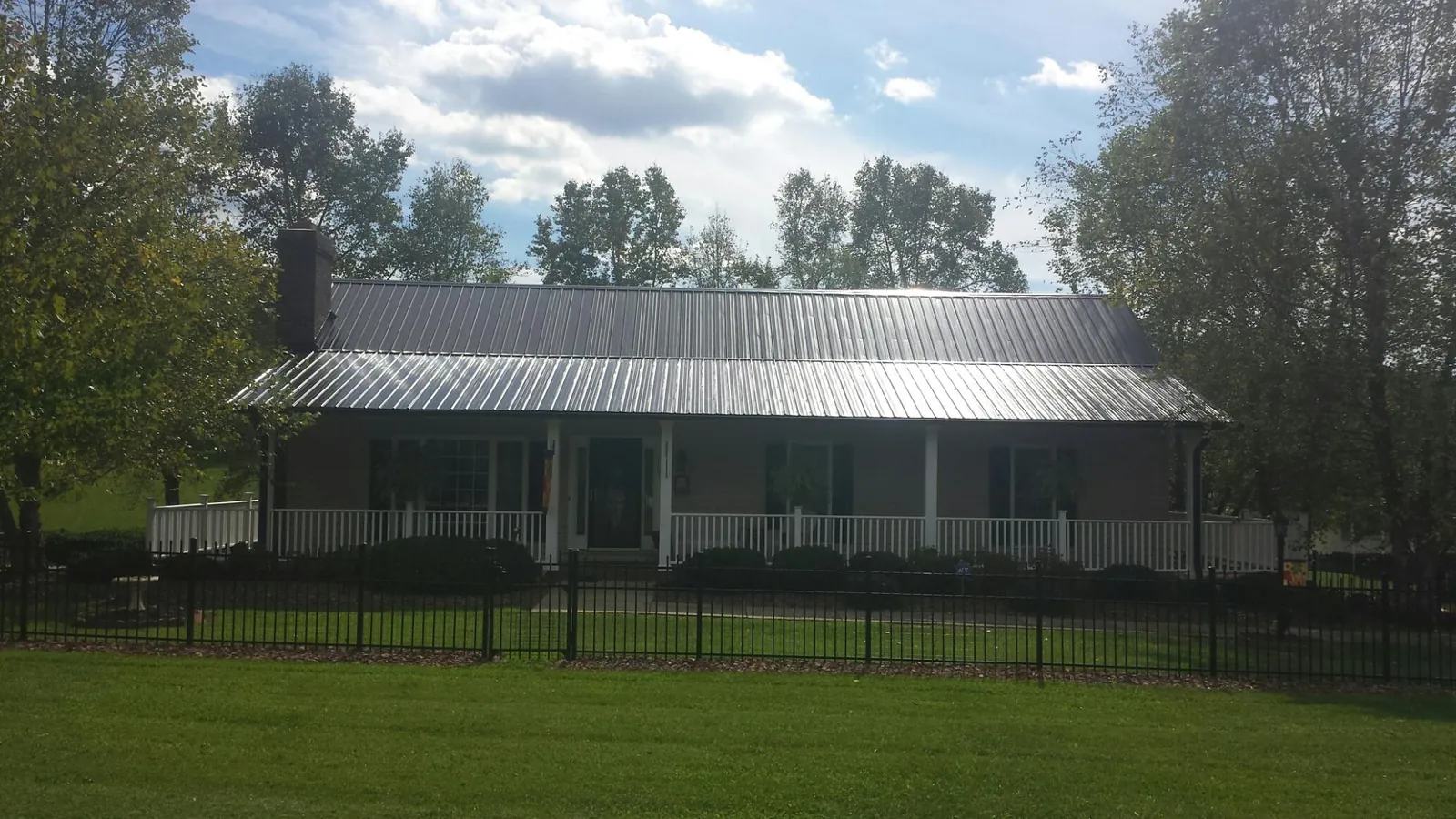 Gray metal roof on a brick ranch with a full width front porch — Gutter Guard Installation work by our crew in Eatontown