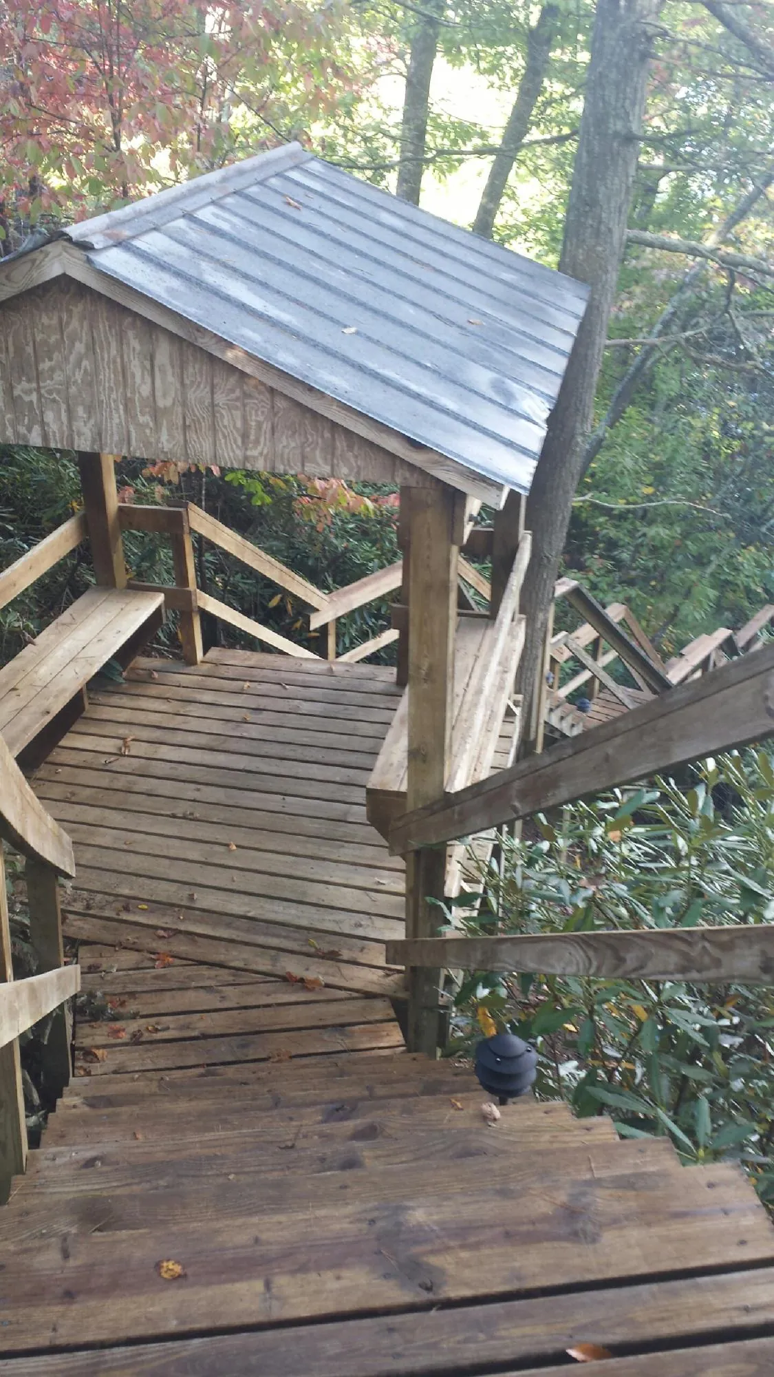 Metal roofed shelter over wooden steps on a wooded walkway — Skylight Repair & Installation work by our crew in Eatontown