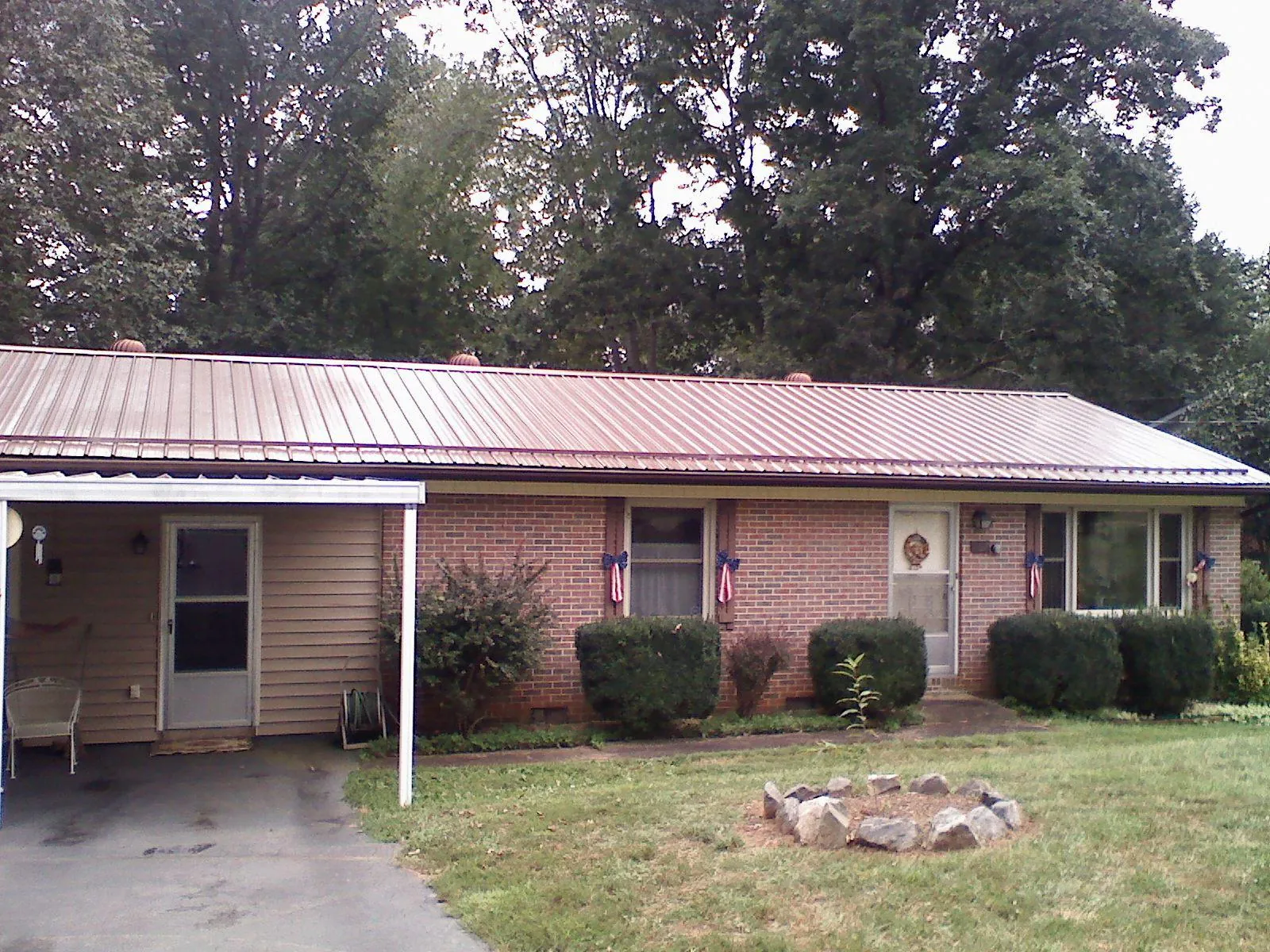 Bronze metal roof and carport on a brick ranch home — Roof Repair work by our crew in Eatontown